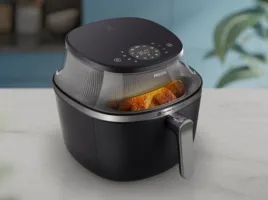 Air fryer Philips Walita preta apoiada sobre bancada de granito claro em cozinha bem iluminada