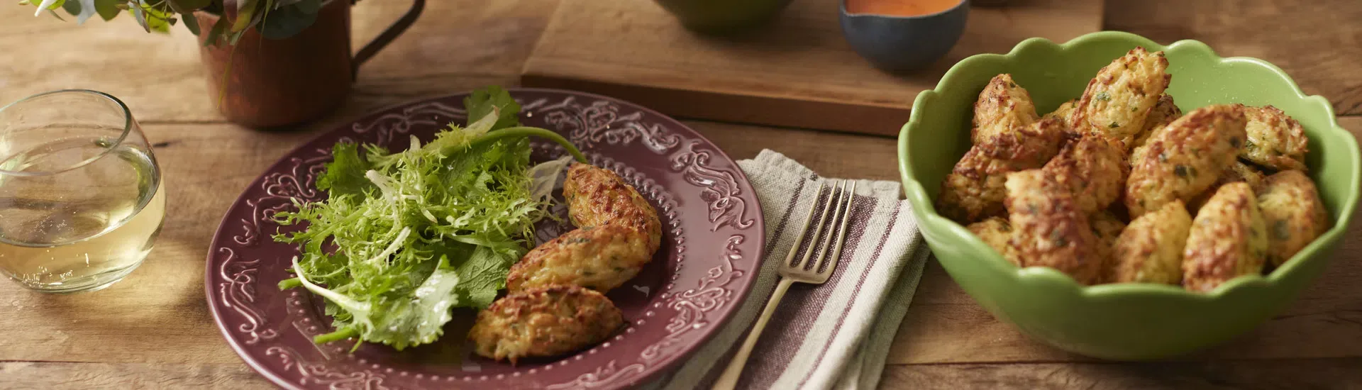 Bolinhos de arroz dourados dentro de uma air fryer preta sobre uma bancada de mármore